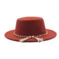 Nahaufnahme eines rostbraunen Flachtür-Filzhutes mit eleganter Perlenkette und Quasten-Details. - M (56-58cm) / Fedora / Karamellbraun