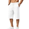 Close-up detail of men's white textured casual shorts with elastic drawstring waist and pockets. - S / White