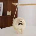 Dettaglio della borsa a tracolla rotonda in paglia con orsetto di peluche e fiocco. - Taglia unica / Crema