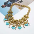 Detailed view of bohemian vintage chunky statement necklace with turquoise stones and gold chain. - Antique Gold