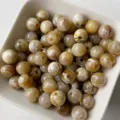 Primo piano dettagliato di perline rotonde in acrilico marrone per gioielli fai da te. - Perlina Tonda (Stile 05)