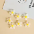 Primo piano di graziose perline di fiori in acrilico bianco e giallo, ideali per gioielli fai da te. - Bianco