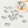 Primo piano dettaglio di perline smiley in acrilico bianco con stampa nera per fai da te. - Grande Confezione da 10 Pezzi (9mm) / Faccina Sorridente Bianca