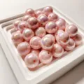 Primo piano dettagliato di perline rotonde in resina rosa con finitura iridescente. - Rosa