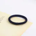 Primo piano dettagliato del elastico per capelli nero minimalista con perla cilindrica. - Stile 4 / 5 Pezzi/Pacchetto