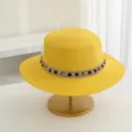 Detailansicht eines stilvollen gelben Strohhuts mit flacher Oberseite und schwarzem Goldband. - M (56-58cm) / Gelb