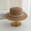 Detailansicht mit feiner Strohgewebestruktur, flacher Oberseite und Perlendekorband. - M (56-58cm) / Khaki