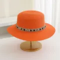 Detailaufnahme des orangen Strohhuts mit flacher Krone, funkelndem Strassband und feinem Flechtwerk. - M (56-58cm) / Orange