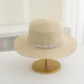 Detailansicht des eleganten Sommer-Strohhutes mit schickem Perlen-Webband und breiter Krempe. - M (56-58cm) / Beige