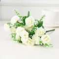 Gros plan détaillé d'un bouquet de roses artificielles blanches avec feuilles vertes. - Blanc