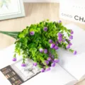 Vue rapprochée de petit bouton de rose eucalyptus artificiel, fleur mauve et feuille verte. - Violet