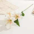 Vue détaillée d'une branche de lys artificiel avec trois fleurs, pétales et feuilles réalistes. - Champagne