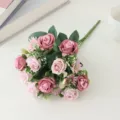 Vue détaillée d'un bouquet de roses artificielles en soie rose avec des pétales fins et des feuilles. - Rose rouge