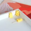 Primo piano di graziose perline in acrilico a forma di orsetto giallo per gioielli fai da te. - Giallo