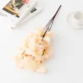 Gros plan d'une branche de fleurs de cerisier artificielles sur table blanche avec livres. - Champagne