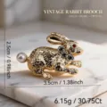 Broche de conejo vintage en aleación dorada, con cola de perla, ojo de cristal rojo y pedrería. - Dorado