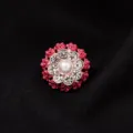 Detailopname van de prachtige strass-bloemkraag decoratieve knoop met een centrale parel. - Rode Roos Stijl