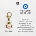 Gros plan sur le charm mousqueton doré avec coccinelle émaillée rose sur carte de présentation. - 22