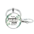 Detailopname van zilveren metalen sleutelhanger met inspirerende quote en groene bladeren. - Stijl 7