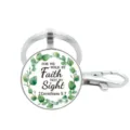 Close-up van een zilveren metalen sleutelhanger met glazen cabochon en eucalyptuskrans. - Stijl 11