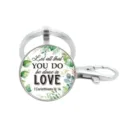 Gedetailleerde opname van een zilveren metalen sleutelhanger met botanische hanger. - Stijl 12