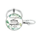 Close-up detail van de ronde glazen sleutelhanger met botanische bladeren en spirituele tekst. - Stijl 16
