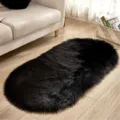 Gedetailleerd opname van een ovaal zwart imitatiebont vloerkleed, zacht pluche woonkamertapijt. - 40x60cm Ovaal Speciale Aanbieding / Zwart