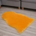 Yellow faux fur rug, irregular fluffy sheepskin bedside mat for cozy bedroom floor decor. - Golden Camel