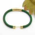Green braided leather bracelet detail, featuring a polished gold stainless steel clasp. - Style 5