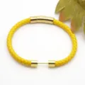Detailed view of the yellow braided leather bracelet with golden stainless steel magnetic clasp. - Style 7