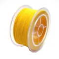 Gedetailleerd close-up van heldergeel elastisch kralenkoord op transparante plastic spoel. - Ca. 0.3mm 50m / Goudgeel
