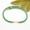 Green braided cord bracelet with gold metal slider components, elegant and adjustable design. - Green