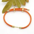 Orange braided leather bracelet cord with gold metal sliding beads and end caps for DIY jewelry. - Orange