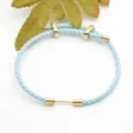 Light blue braided leather bracelet with gold metal rings stylish accessory for daily wear. - Light Blue
