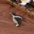 Close-up view of a sparkling crystal penguin brooch with gold tone metal for women. - Penguin Brooch / 4.9 x 3.5 cm
