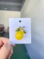 Detailed view of the enamel lemon brooch featuring vibrant yellow color and green leaves. - Lemon / 4x3.2cm / Yellow