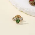 Close-up detail shot of a sparkling rhinestone and green enamel bee brooch fashion accessory. - Bee 5