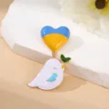 Detailed view of enamel peace dove and blue yellow heart brooch fashion accessory pin. - Yellow