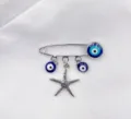 Gedetailleerde close-up opname van een zilveren veiligheidsspeld broche met blauwe kralen en ster. - Zeesterstijl (1)