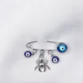 Zilveren veiligheidsspeld broche met blauwe boze oog kralen en spin hanger mode. - Spin Stijl (2)
