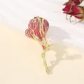 Gedetailleerd close-up van de prachtige vergulde roze geëmailleerde bloembroche met parel. - Roze Tulp
