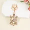 Detailed view of a gold-tone rhinestone crystal turtle keychain and stylish bag charm pendant. - White Turtle / 12.5*3.6cm / White