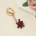 Close-up of cute turtle rhinestone keychain detail, shining red crystals and gold hardware display. - Full Rhinestone Enamel Multicolor Turtle / 10*2.7*1.5cm / Full Rhinestone Enamel Multicolor