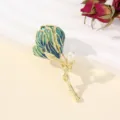 Detailopname van prachtige vergulde bloemvormige broche met blauw email en parel. - Blauwe Tulp