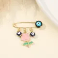 Detailed close-up of gold-tone safety pin brooch featuring blue evil eye beads and pink rose. - Pink Rose and Evil Eye Style