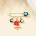 Gold-tone safety pin brooch featuring blue evil eye beads and red rose enamel pendant for women. - Red Rose and Evil Eye Style