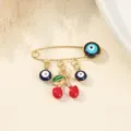 Gros plan détaillé sur la broche épingle de sûreté œil maléfique avec pendentif cerise. - Style Cerise Rouge / 3.8x2.8cm