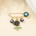 Detailed close-up of a creative fashion brooch featuring blue evil eye charms and black rose. - Black Rose and Evil Eye Style