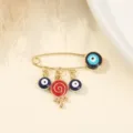 Gold-tone evil eye safety pin brooch featuring a cute red swirl lollipop charm and blue accents. - Red Lollipop and Evil Eye Style