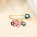 Evil eye butterfly brooch detail close up, gold tone safety pin with blue bead pendant. - Pink Enamel Butterfly Style (7)